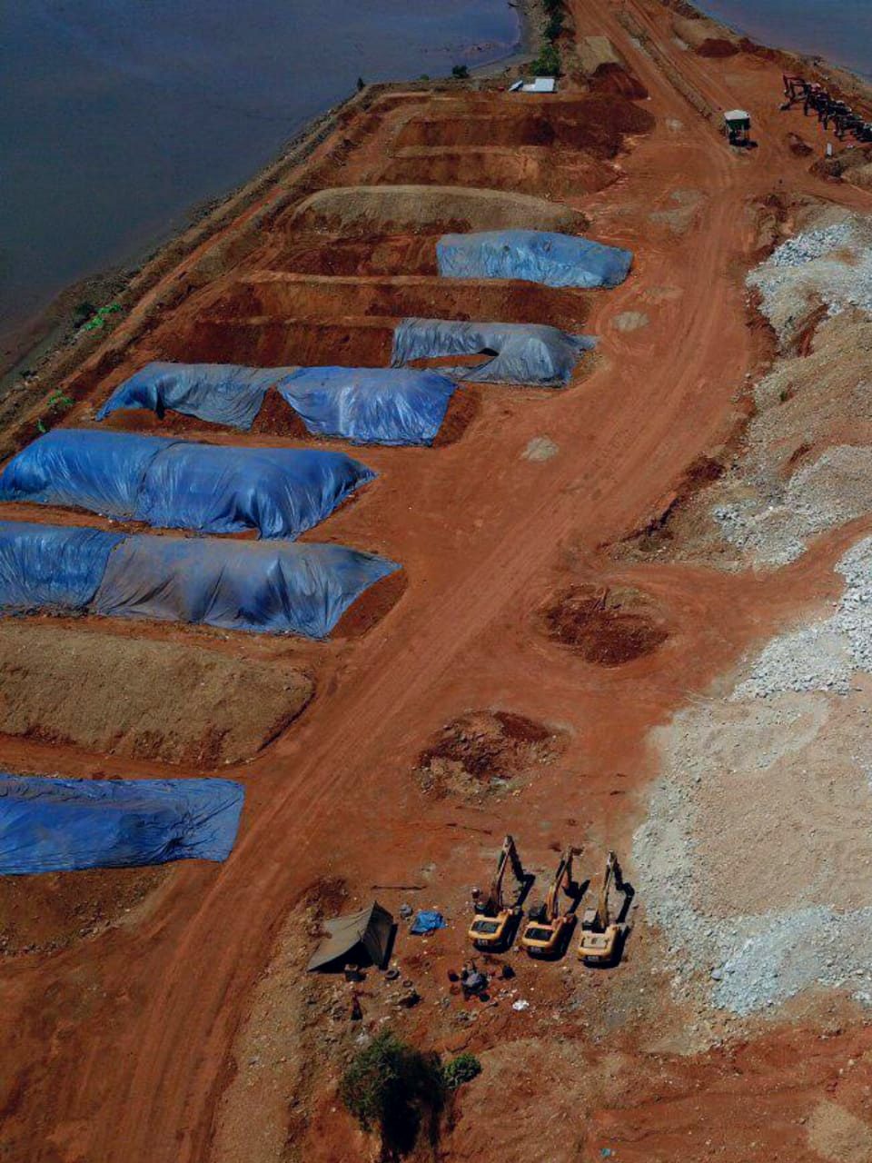 Foto aerial lokasi tambang dengan stockpile tertutup terpal